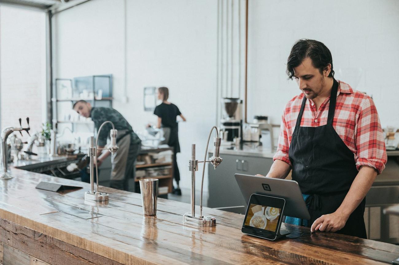 A barista using a tablet at the counter