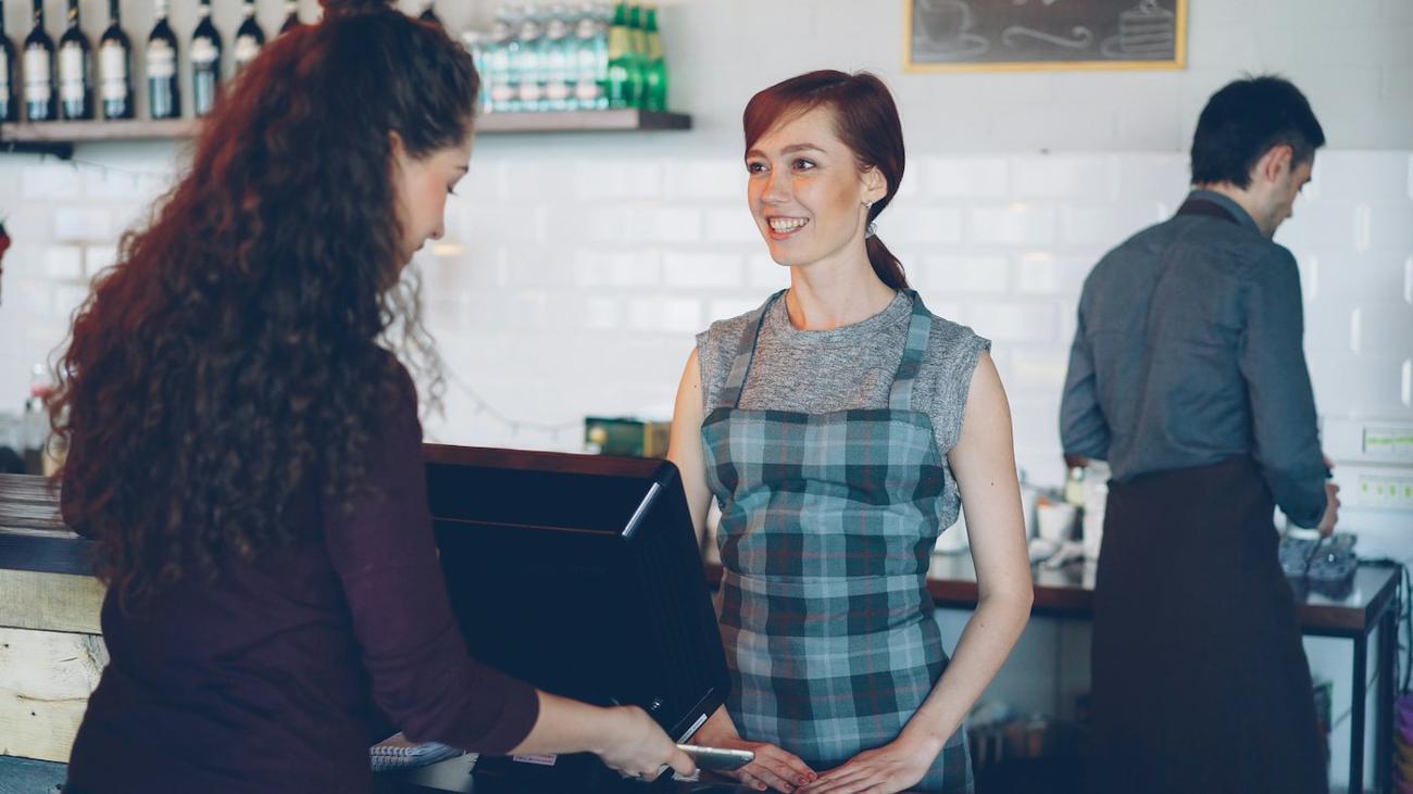 Two members of staff working behind a counter